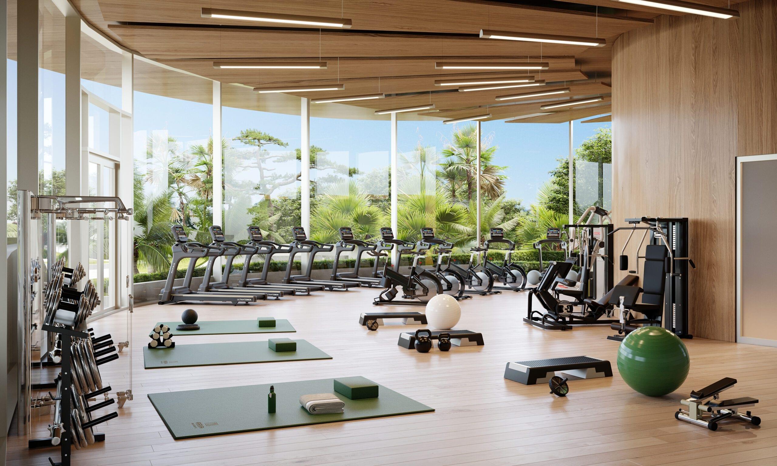 Modern fitness center with exercise equipment, yoga mats, and large windows overlooking greenery at Aria Reserve Residences.